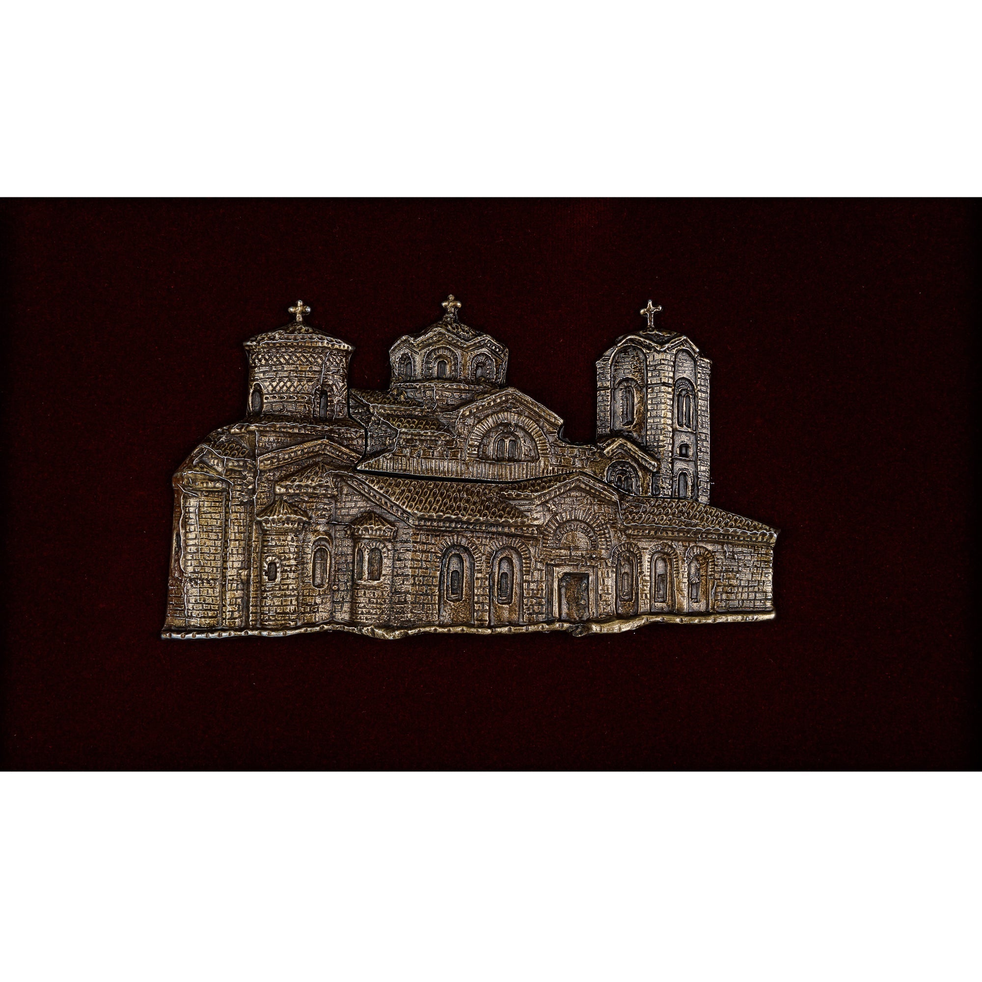 Детален приказ на металниот релјеф со антик патина, истакнувајќи ги препознатливите куполи и византиската архитектура на манастирот на Плаошник.