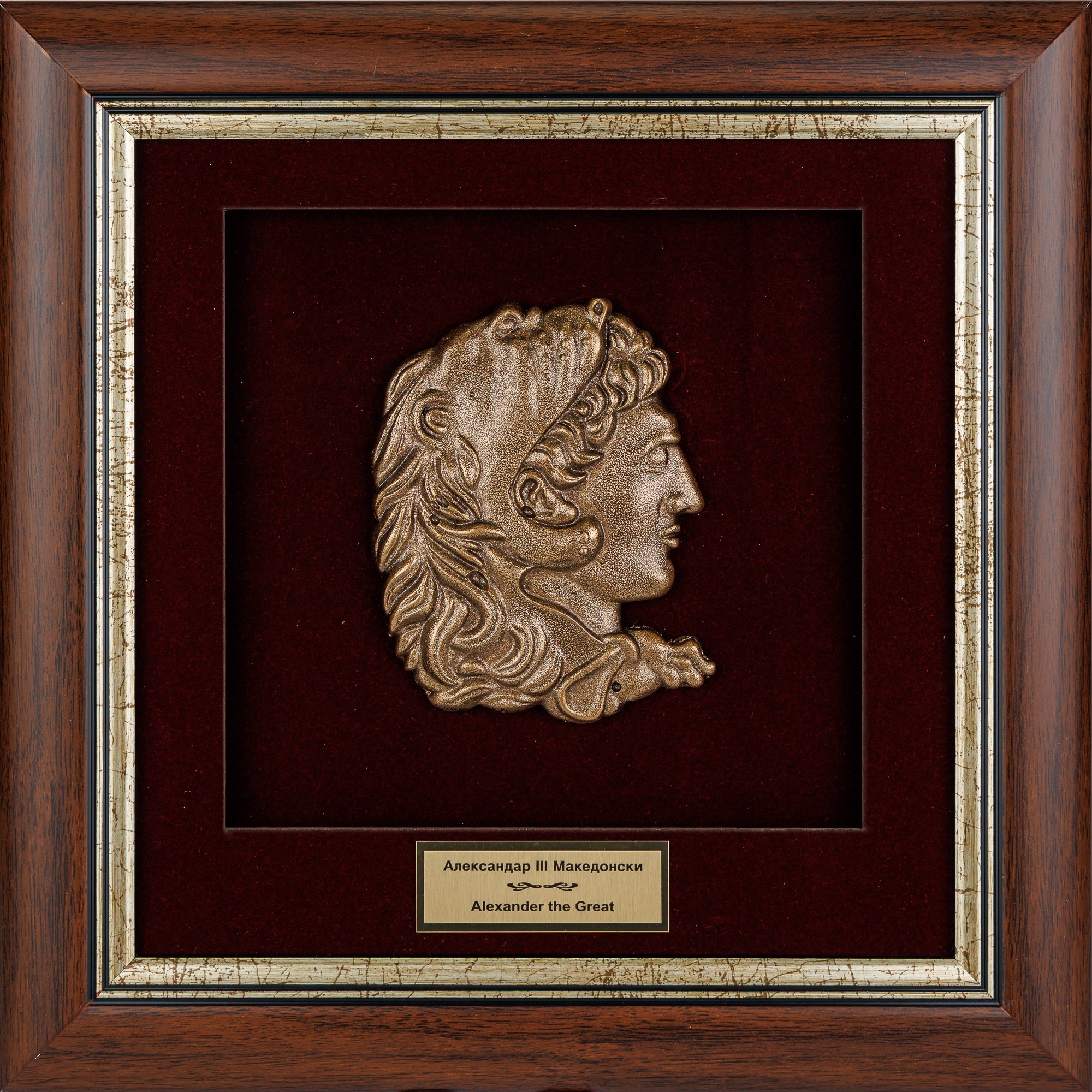Елегантно врамен метален релјеф на Александар Велики со лавовска кожа на бордо кадифе во масивна дрвена рамка, ексклузивен историски сувенир од ВЕКОВИ.