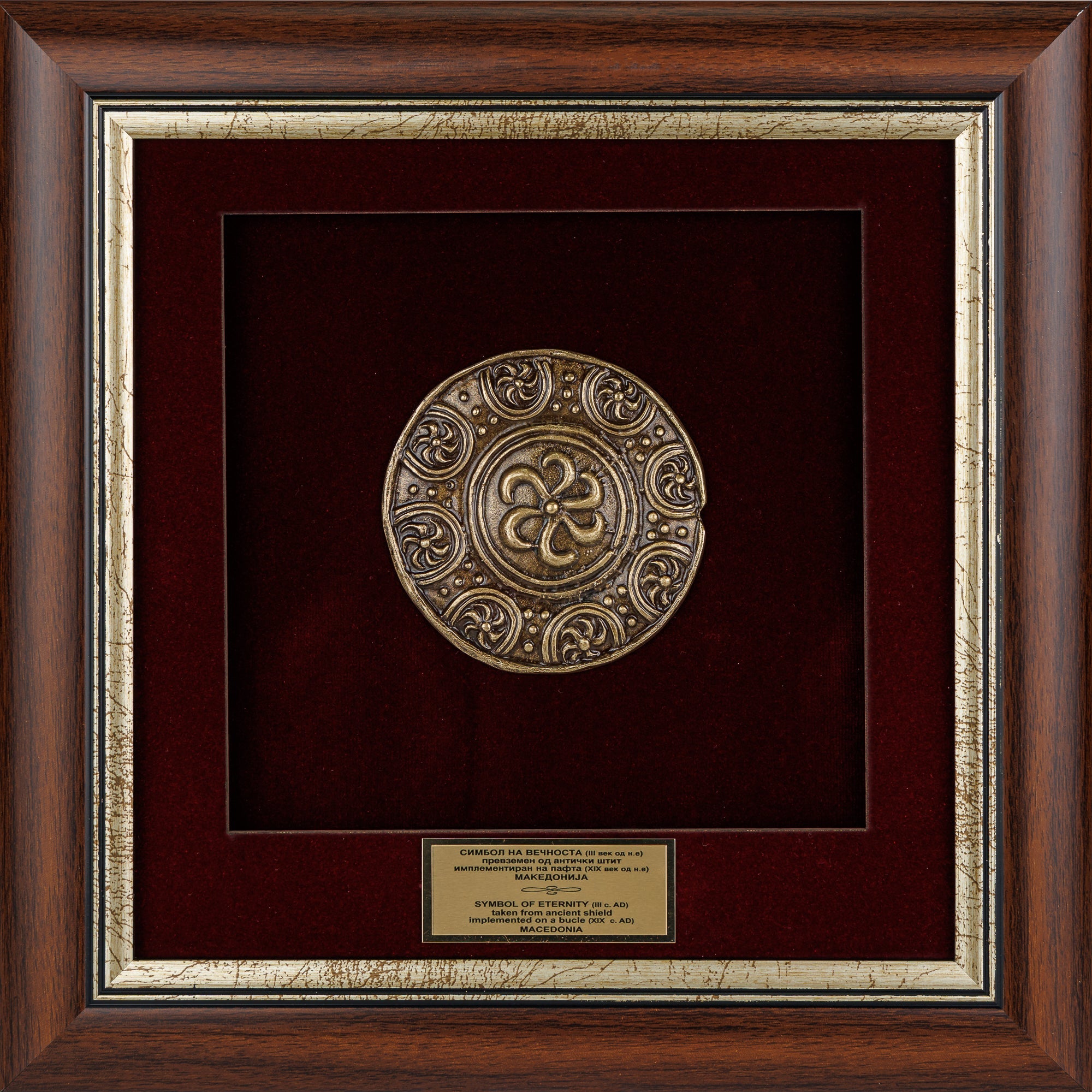 Елегантно врамен метален релјеф на Македонски штит - Симбол на вечноста на бордо кадифе во масивна дрвена рамка, ексклузивен антички сувенир од ВЕКОВИ.