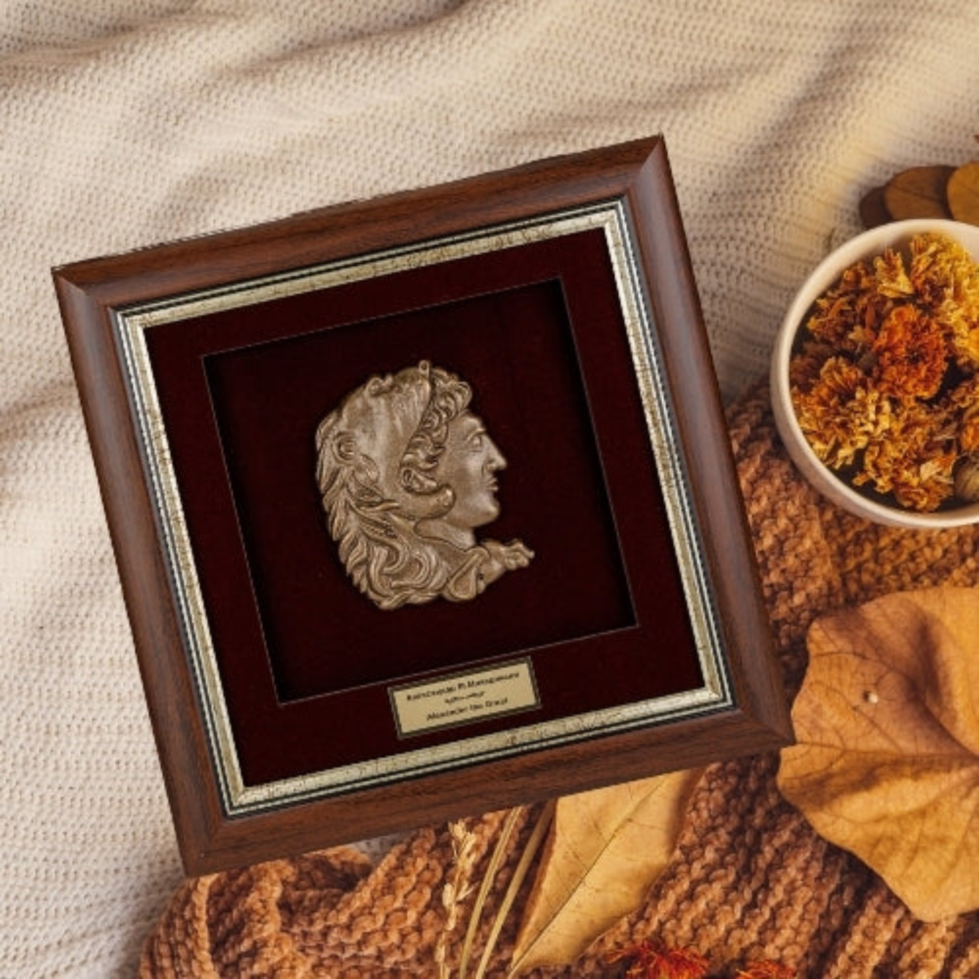 Врамената реплика на Александар Македонски нежно поставена во топол есенски амбиент, идеален сувенир кој го слави македонското наследство.