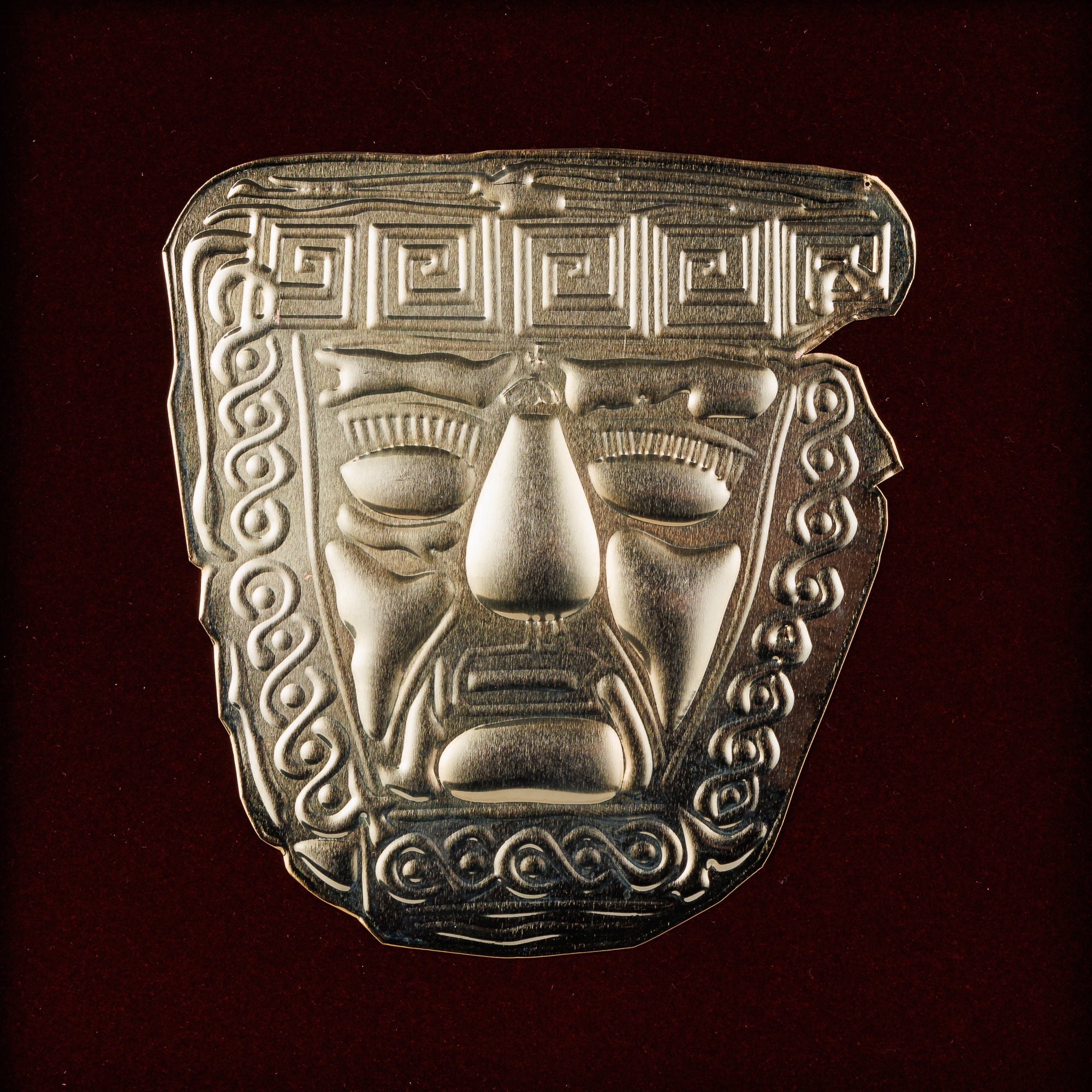 Детален приказ на блескавата позлатена маска од 6-тиот век п.н.е., мајсторски доловувајќи ги сложените геометриски гравури и експресивниот лик.