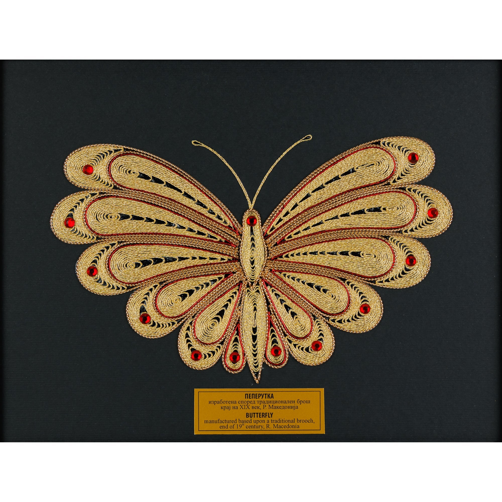 Детален приказ на симетричните шари и црвените камења на филигранската Пеперутка изработена од 100% природна срма.