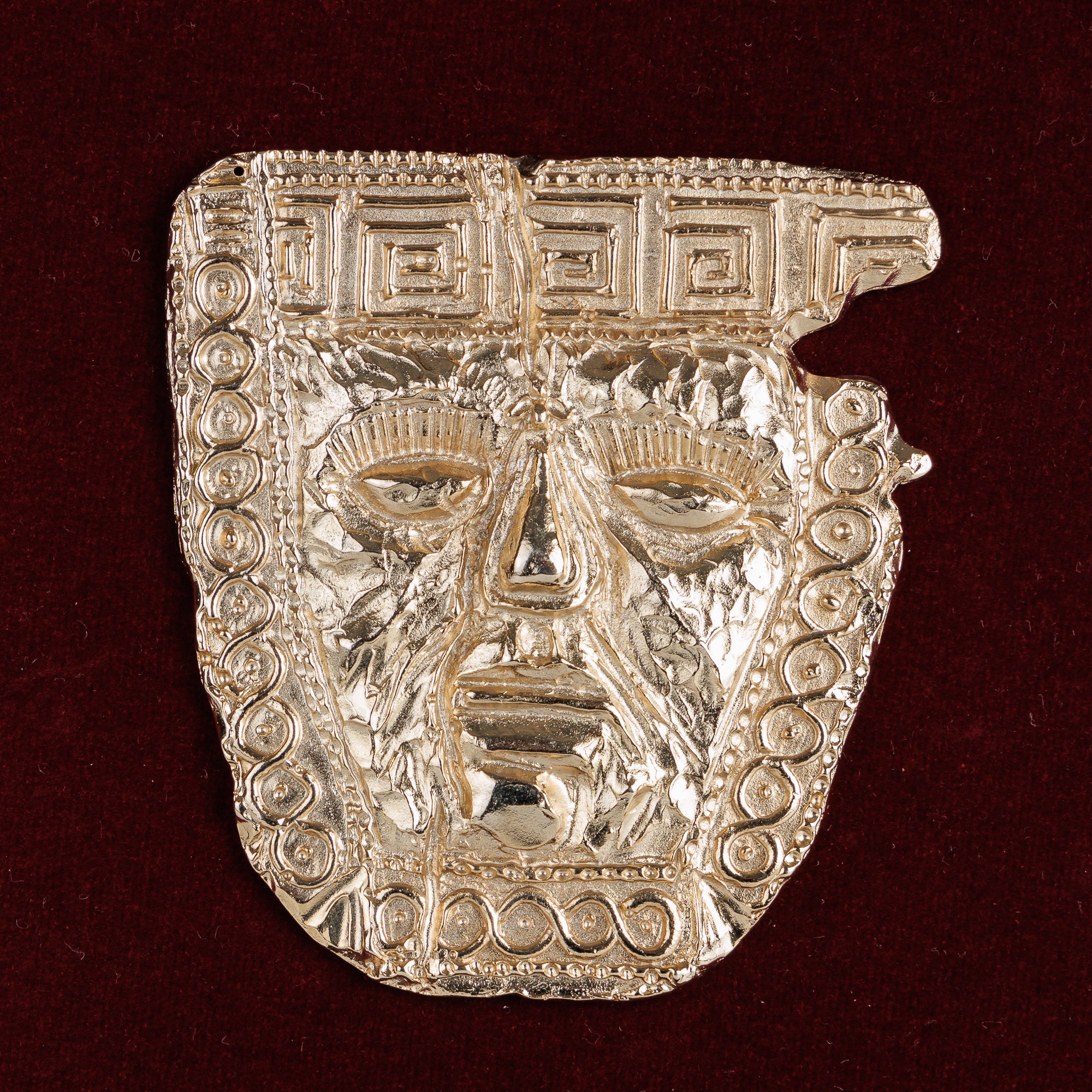 Крупен кадар кој мајсторски ги доловува карактеристичните спирални мотиви и величествениот израз на лицето на оваа античка маска.