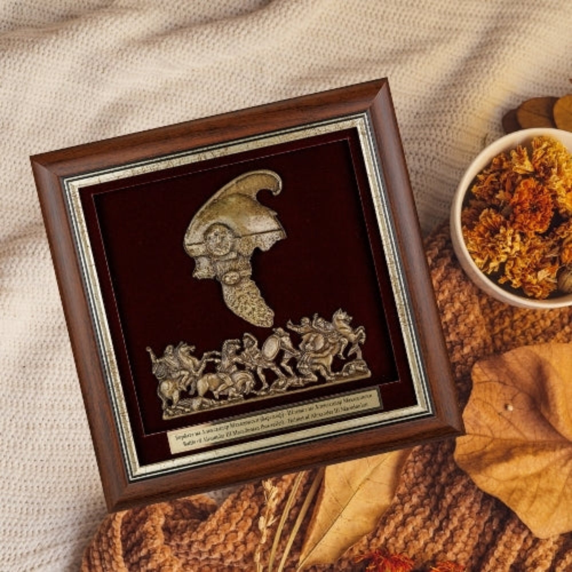 Врамената реплика на шлемот на Александар Велики нежно поставена во топол есенски амбиент, идеален сувенир кој симболизира храброст и моќ.