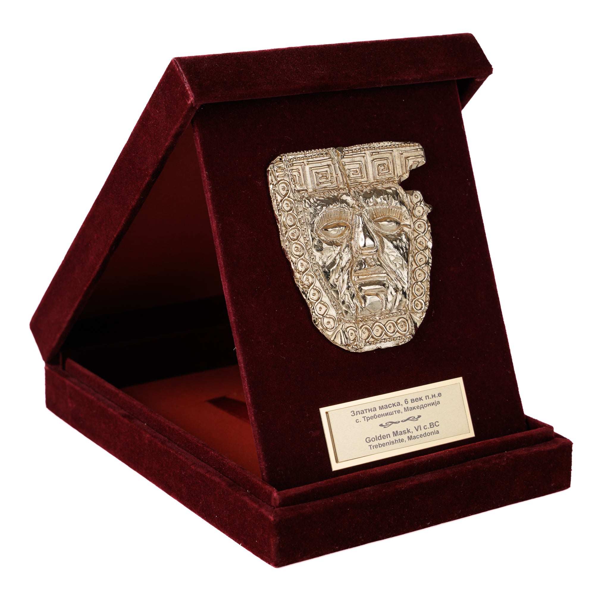 Луксузна бордо кадифена кутија поставена како држач, откривајќи блескава музејска реплика на прочуената Златна Маска од Требеништа од ВЕКОВИ.
